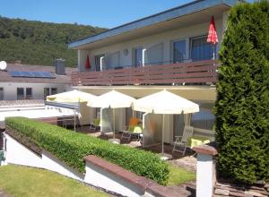 a building with umbrellas and chairs in front of it at Pension Genz in Bad Karlshafen