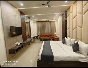 a hotel room with a large bed and a television at Hotel Bhumi Residency in Pānīpat