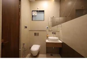 a bathroom with a toilet and a sink and a mirror at Hotel Bhumi Residency in Pānīpat