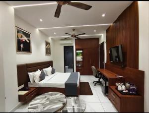 a bedroom with a bed and a desk and a television at Hotel Bhumi Residency in Pānīpat