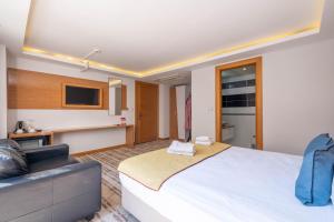 a bedroom with a large white bed and a couch at Bulvar Hotel in İzmir +43 photos