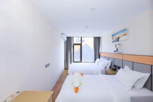 a hotel room with two beds with a teddy bear sitting on top at Zhuoya Garden Hotel in Beijing