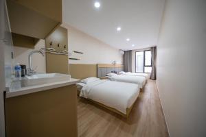 a hotel room with two beds and a sink and a bathroom at Zhuoya Garden Hotel in Beijing +24 photos