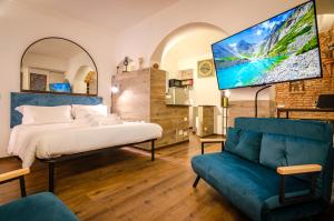 a bedroom with a bed and a couch and a tv at Medieval central apartment in Bologna