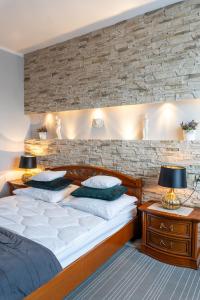 a bedroom with two beds and a brick wall at Apartamenty Blisko Centrum in Toruń
