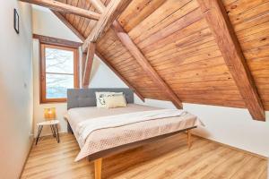 a bedroom with a bed in a room with wooden ceilings at Stadel Lipno in Černá v Pošumaví