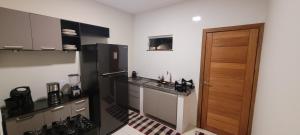 a kitchen with a black refrigerator and a wooden door at Casa aconchegante e estruturada in Bragança