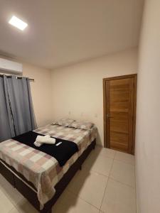 a bedroom with a bed and a wooden door at Casa aconchegante e estruturada in Bragança +2 photos