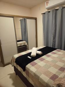 a bedroom with a bed and a mirror with towels on it at Casa aconchegante e estruturada in Bragança