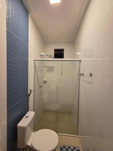 a bathroom with a toilet and a glass shower at Casa aconchegante e estruturada in Bragança