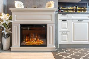 a white fireplace in a kitchen with a stove at Apartamenty Blisko Centrum in Toruń