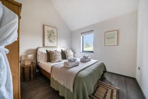 a bedroom with a bed with towels on it at Grove Cottage in Kington