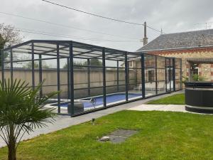 a pavilion with a swimming pool inside of a building at Gîte with pool & Nordic bath in Monthois