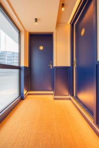 an empty room with blue doors and a window at CP Apartments San Mamés in Bilbao