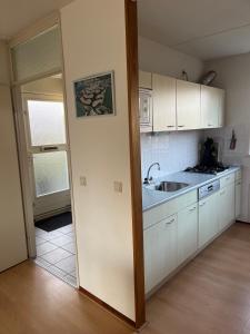 a kitchen with white cabinets and a sink at Ark in Terherne
