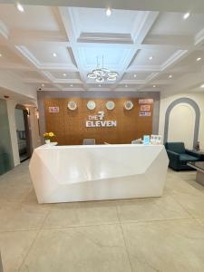 a lobby with a white reception desk in a building at The 7 elevan hotel in Sānand +19 photos