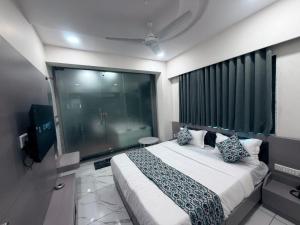 a bedroom with a large bed and a large window at The 7 elevan hotel in Sānand