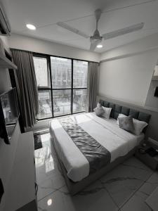 a bedroom with a large bed with a large window at The 7 elevan hotel in Sānand