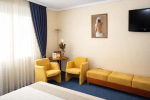 a hotel room with two chairs and a couch and a table at Motel Punta Cana in Santiago de Compostela