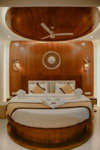 a bedroom with a large bed with a wooden headboard at Green View Suites in Kalyānpur +75 photos