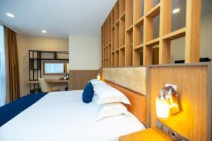 a bedroom with a large white bed and a desk at New Wave Hotel in Batumi