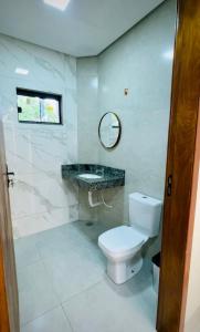 a bathroom with a toilet and a sink and a mirror at Giacomelli Plaza Hotel in Rio Verde