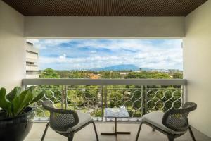 a balcony with two chairs and a large window at Royal Ambarrukmo Yogyakarta in Yogyakarta