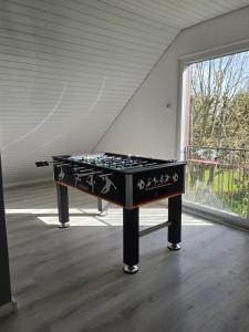 a pool table in a room with a window at Großes (ca.230m²) freistehendes Einfamilienhaus in Kaltenkirchen