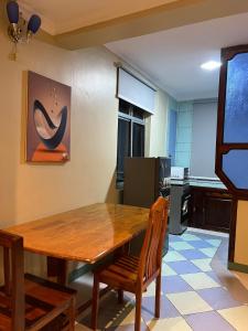 a dining room with a wooden table and chairs at Capri Hills 4 in Mwanza