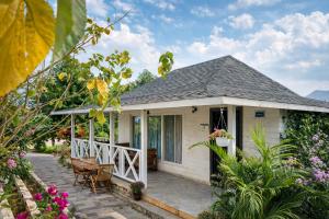 a white house with a porch and flowers at Sierra Vista Resort in Nashik