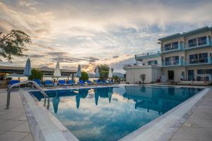 a pool at a hotel with chairs and umbrellas at Cliff Bay Hotel by GHH in Paleros