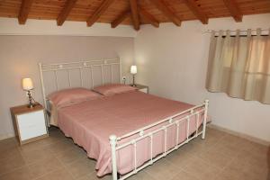 a bedroom with a bed with pink sheets and a window at Lina`s Apartment & Maisonette in Neo Klima
