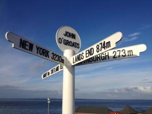 a pole with street signs on the beach at Pennan - 2 Bed Luxury Apartment by Together Travel in Wick