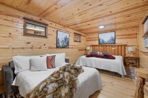 a bedroom with two beds in a log cabin at Bison Trail House- Rustic Cabin Retreat in Rapid City