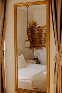 a mirror reflecting a bed in a room at Vila Perast Boutique Hotel in Perast