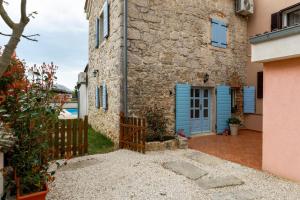 a house with a blue door and a fence at Casa Lampadina in Vižinada