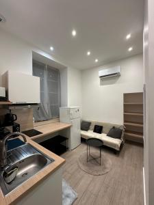a kitchen with a sink and a couch in a room at Magnifique appartement neuf Bellecour in Lyon