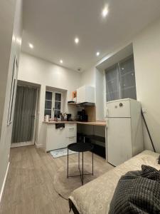 a small kitchen with a white refrigerator and a table at Magnifique appartement neuf Bellecour in Lyon