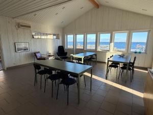 a large room with tables and chairs and windows at Open Water Lodge Smögen in Smögen