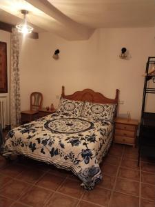 a bedroom with a bed with a black and white comforter at Casa Rural Las Mieles in Chillarón del Rey