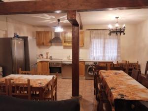 a kitchen with wooden tables and a kitchen with a refrigerator at Casa Rural Las Mieles in Chillarón del Rey