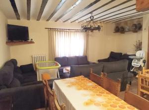 a living room with couches and a table at Casa Rural Las Mieles in Chillarón del Rey