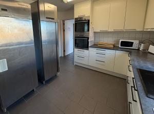 a kitchen with white cabinets and stainless steel appliances at Open Water Lodge Smögen in Smögen +23 photos