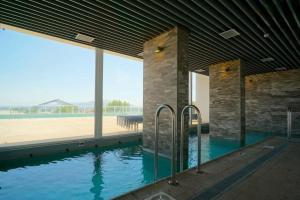 a swimming pool in a building with a view of a beach at Gran espacio para descansar cerca de todo in Concón