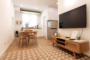 a living room with a table and a large flat screen tv at Allrange Home 5 bedroom for 10 guests in Chiang Mai