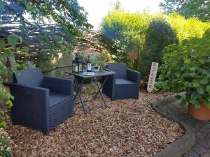two chairs and a table with wine bottles on it at Rotbuche in Ruhwinkel