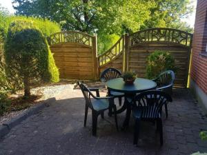 a patio with a table and chairs and a fence at Rotbuche in Ruhwinkel +4 photos