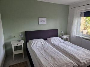a bedroom with a bed with two tables and a window at Rotbuche in Ruhwinkel