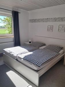 a large bed in a room with a window at Feldblick in Ruhwinkel