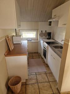 a small kitchen with white cabinets and a sink at Feldblick in Ruhwinkel